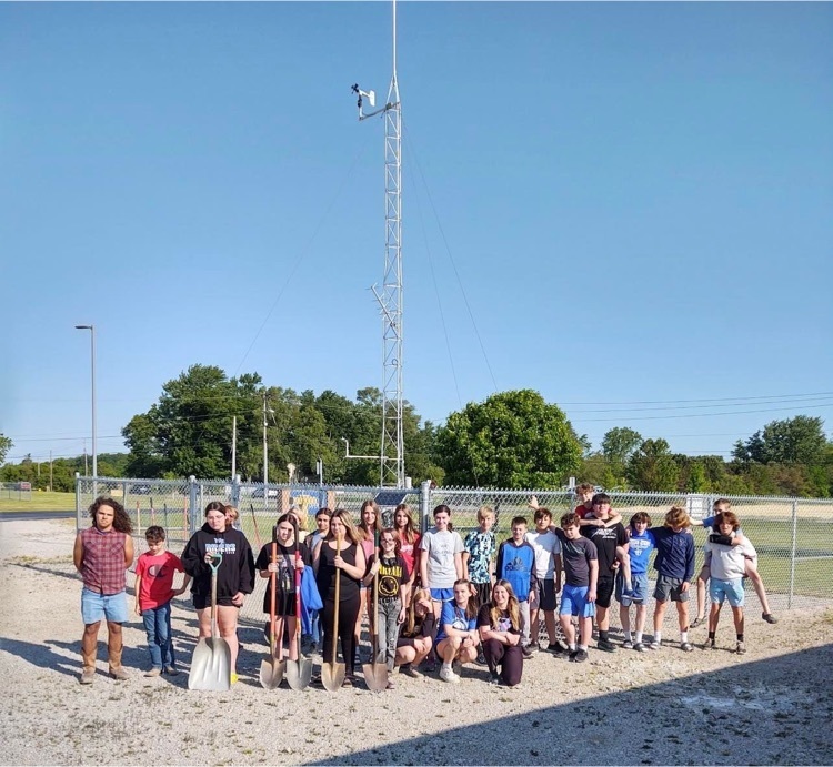 students standing in front of the weather station