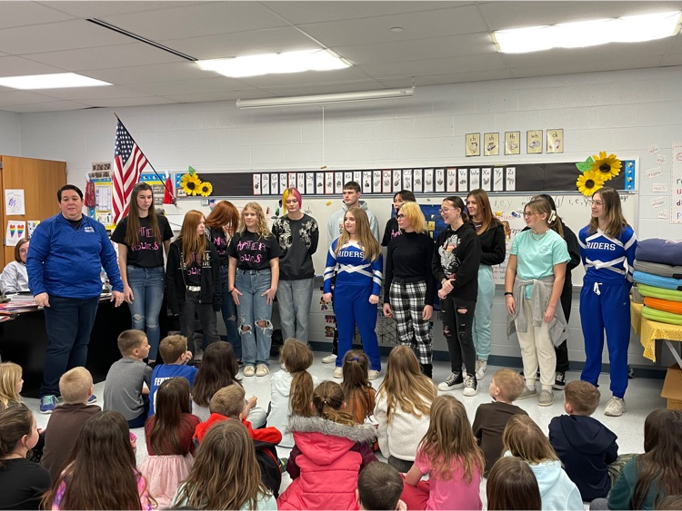 HS students singing to elementary students.