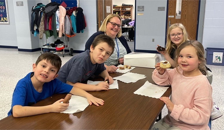 students posing with the donuts with Mrs. Cornelison