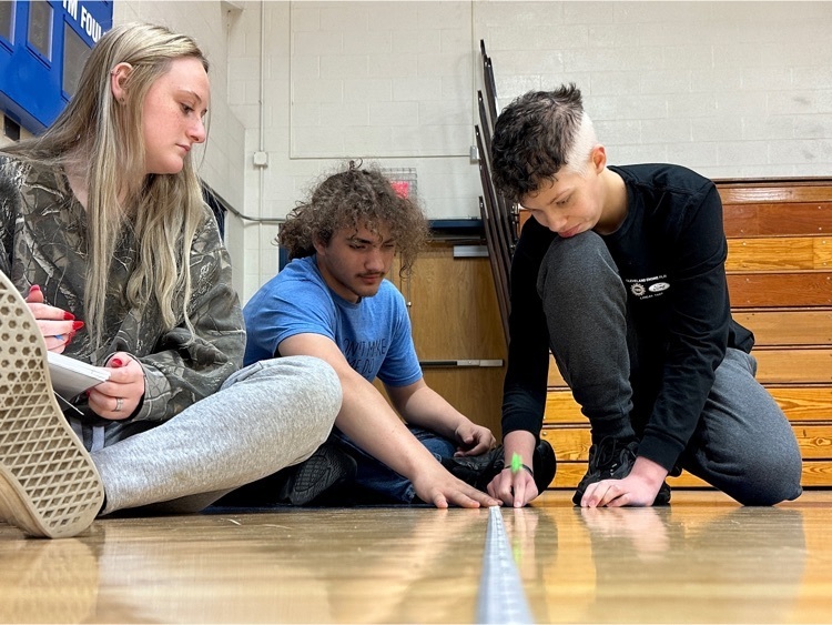 Students in high school conducting experiments in the gym.