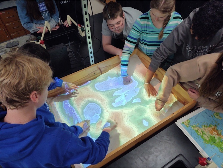 Students engaged in a sand topography activity .