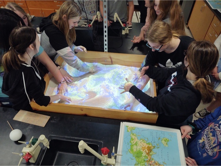 Students engaged in a sand topography activity.
