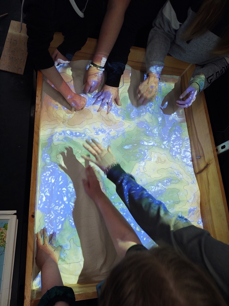 Students engaged in a sand topography activity.
