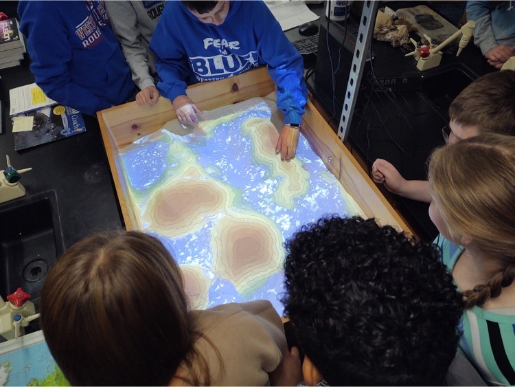 Students engaged in a sand topography activity.